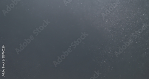 backlit dust particles explosion effect on a black background with motion blur © GCapture
