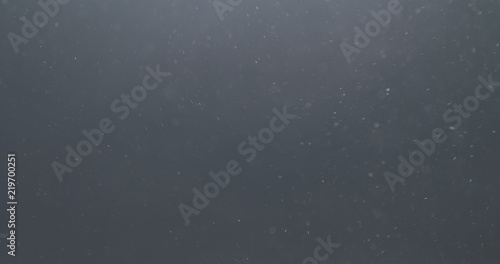 backlit dust particles explosion effect on a black background with motion blur