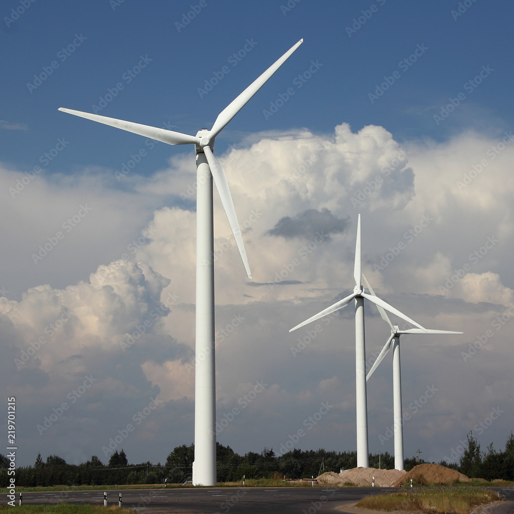 Modern power wind farm in summer against blue sky with white clouds Modern power wind farm in summer against blue sky with white clouds