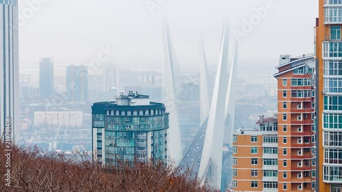 Golden cable-stayed bridge road car traffic from above. Modern Vladivostok Russia night illumination. Old and modern central buildings. Aerial flight 4k footage.	