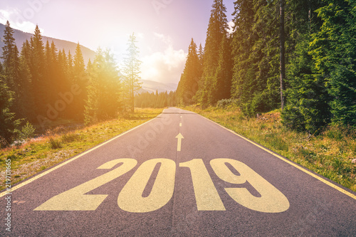 Empty asphalt road and New year 2019 concept. Driving on an empty road in the mountains to upcoming 2019 and leaving behind old 2018. Concept for success and passing time.