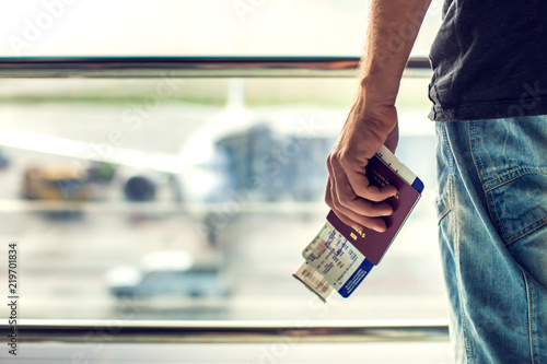 Closeup of man holding passports and boarding pass at airport. Traveling concept photo