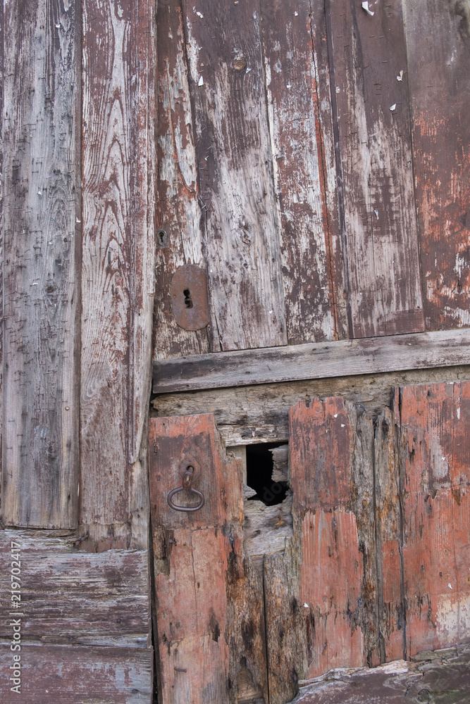 Puerta antigua de madera en casa de piedra de estilo medieval