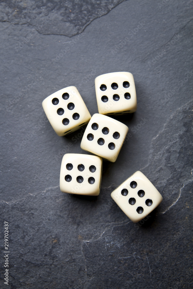 Dice for game on a black background. A system of five identical bones. Dice for game on a black background. A system of five identical bones.