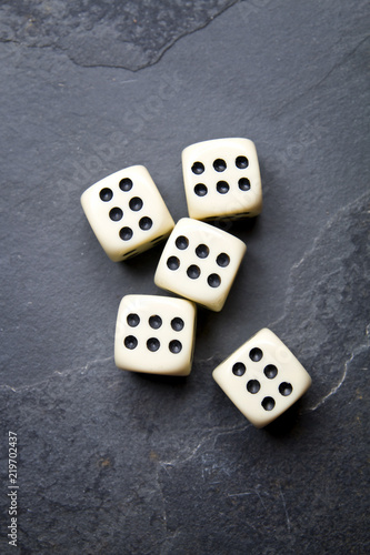 Dice for game on a black background. A system of five identical bones.