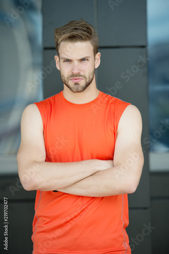 Metrosexual concept. Guy bearded attractive care about style and appearance. Man bristle strict face muscular shoulders urban background. Man with beard muscular guy looks handsome and cool