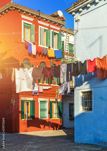 Fototapeta Naklejka Na Ścianę i Meble -  Laundry hanging out of typical houses of Burano Island, Venice, Italy. Multicolored buildings and laundry drying on the street in Burano, Venice, Italy