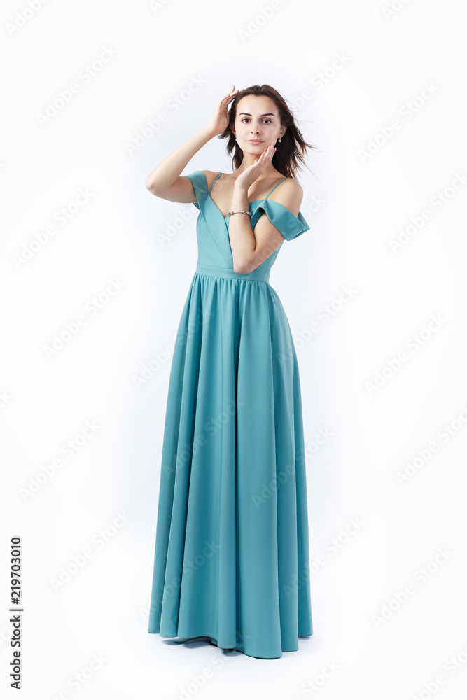 pretty girl is posing in studio in a blue pastel dress