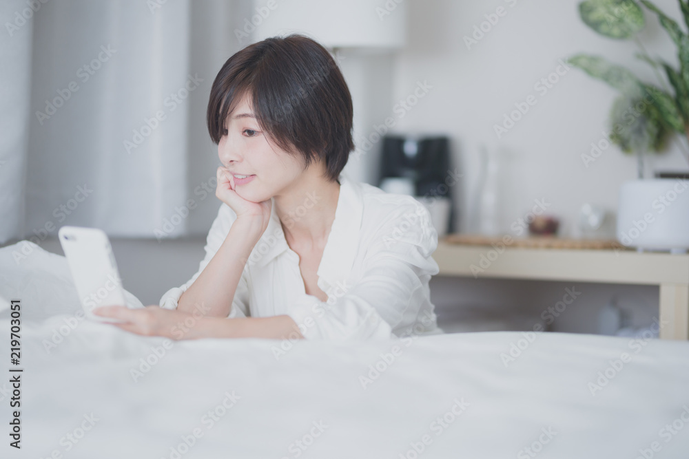 スマホ・女性・ベッドルーム スマホ・女性・ベッドルーム