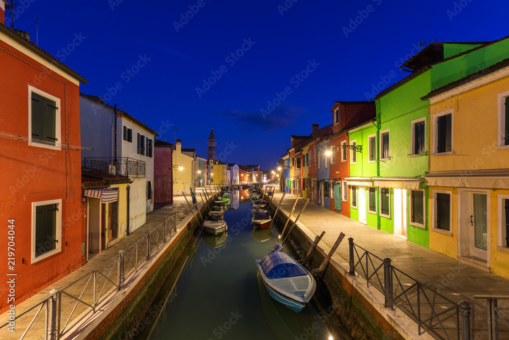 Colorful houses at night in Burano, Venice Italy. Night lights on the beautiful Burano island. Venice, Italy. Colourfully painted houses facade on Burano island in evening, province of Venice, Italy