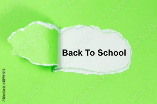 The word Back To School appearing behind torn paper