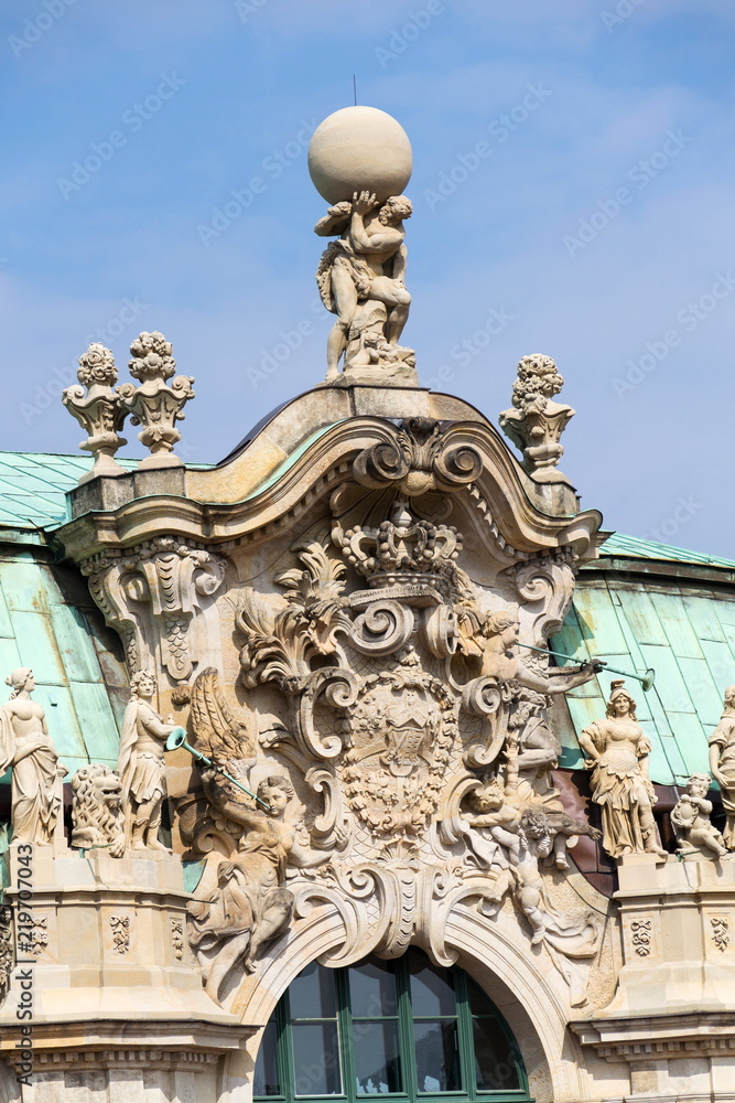 Atlas god statue holding sphere on shoulders, Wallpavillon Zwinger palace, Dresden, Germany, sunny day clear blue sky background