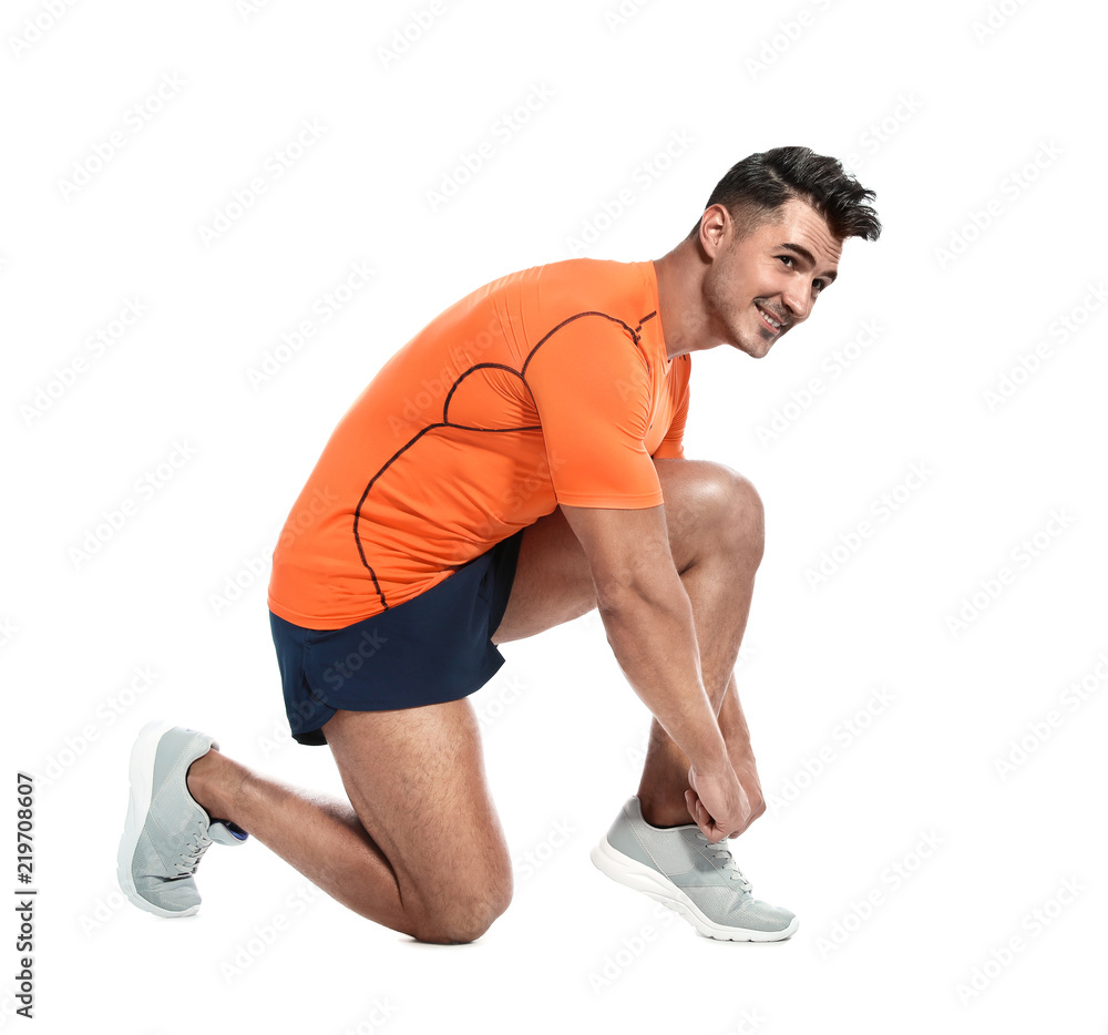 Handsome young runner tying shoelaces on white background Handsome young runner tying shoelaces on white background