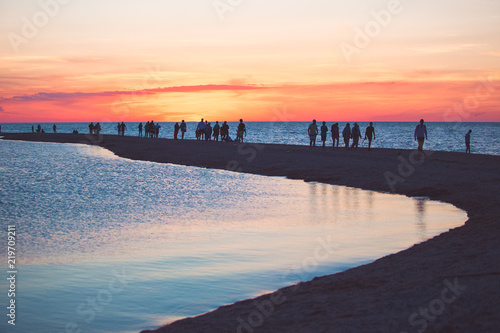 Beautiful seascape with people watching the sunset over the sea © Maksim Kostenko