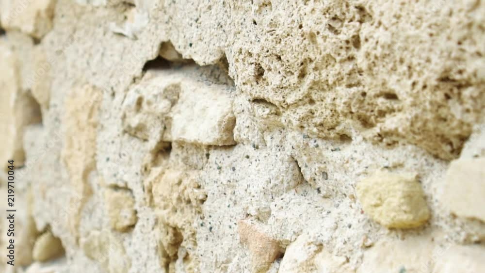 First person POV walking in old city looking at rustic ancient stone wall. Close up european city yellow rocky stones church exterior. Camera moving in slow motion First person POV walking in old city looking at rustic ancient stone wall. Close up european city yellow rocky stones church exterior. Camera moving in slow motion