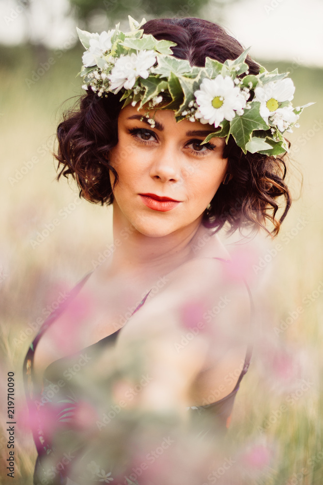 Girl with flower crown posing in the field during sunset Girl with flower crown posing in the field during sunset