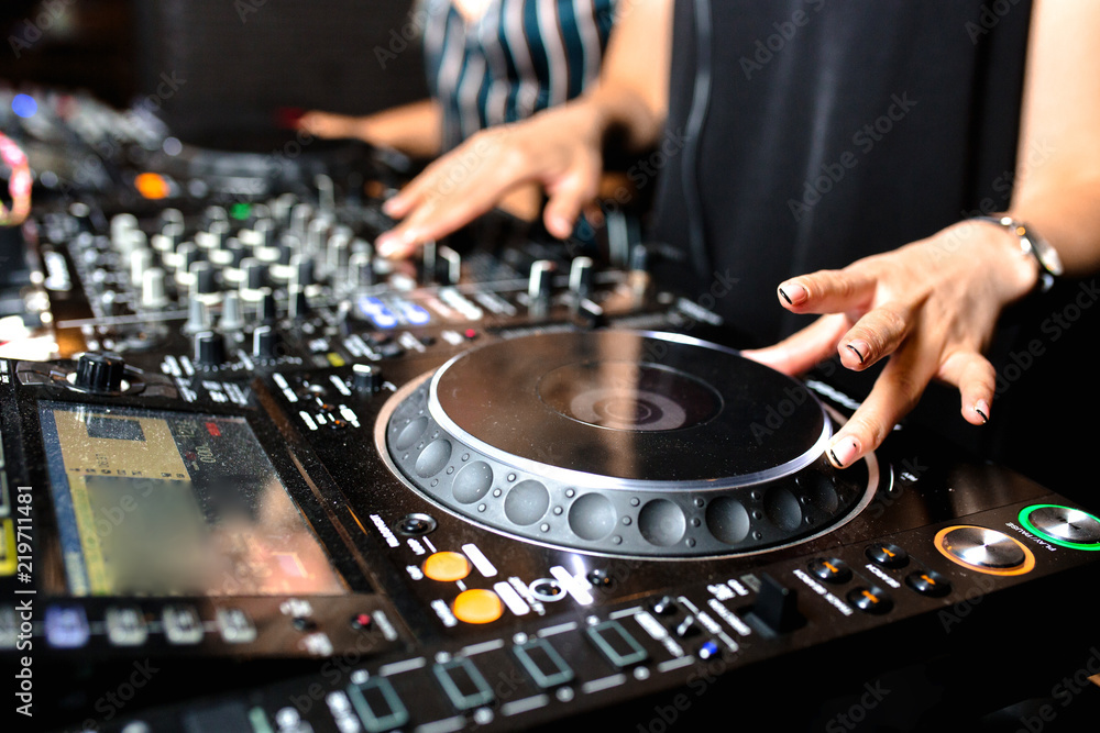Two white young girls party dj audio controlling mixing. Turntable High quality Sound mixing controller disc jockey hands of woman in night club party, Pro audio equipment on stage in nightclub . Two white young girls party dj audio controlling mixing. Turntable High quality Sound mixing controller disc jockey hands of woman in night club party, Pro audio equipment on stage in nightclub .
