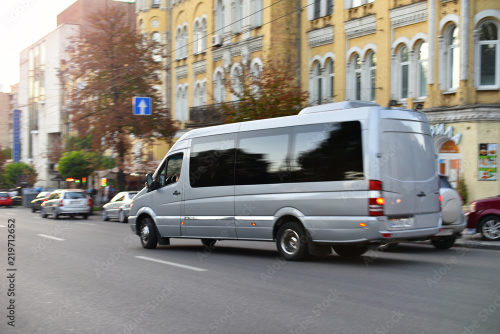 passenger bus van accelerating by city street