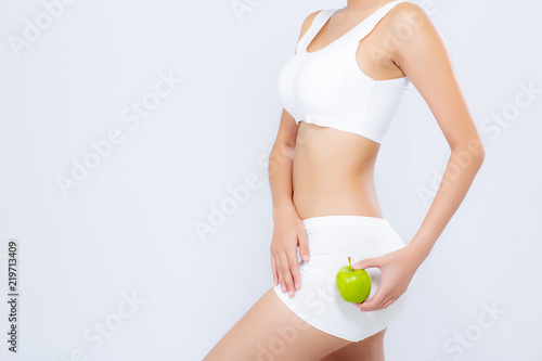 Closeup beautiful body woman sexy slim holding green apple with cellulite for wellness, girl waist thin with fitness for weight loss and healthy isolated on white background, healthcae diet concept. photo