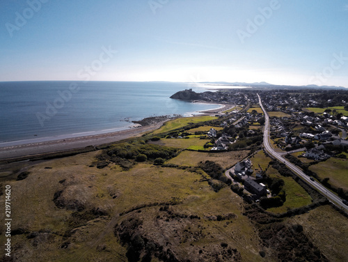 Aerial view, Drone panorama of sea with silhouette of Criccieth castle and town in background