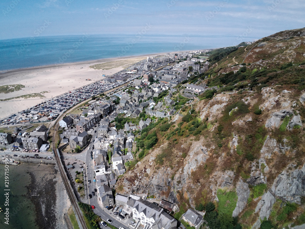 Aerial view, Drone panorama over buildings, railway line, road, beach and old town of Barmouth, Wales