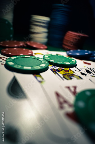 Poker Chips and playing cards on a green felt poker table