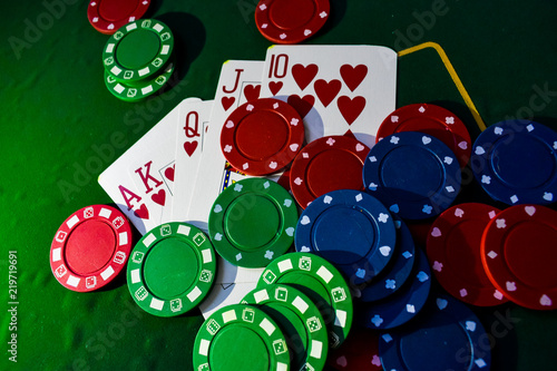 Poker Chips and playing cards on a green felt poker table