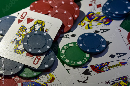 Poker Chips and playing cards on a green felt poker table
