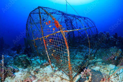 An abandoned, rusting fish trap left on the seabed of a tropical coral