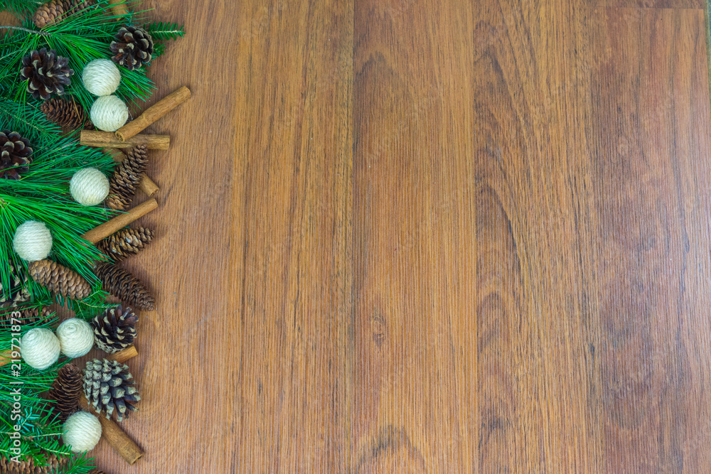 A left side border of greenery with pine cones, cinnamon sticks, and ornaments