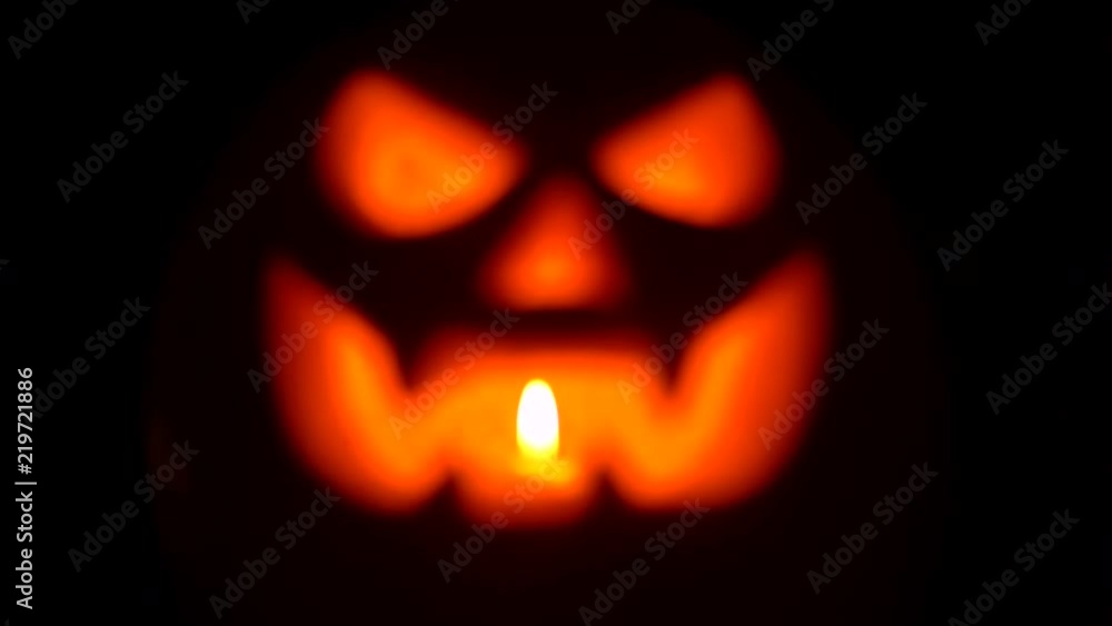 Pumpkin with light inside in darkness. Blurry background. Terrifying symbol of Halloween - Jack-o-lantern. 4k Pumpkin with light inside in darkness. Blurry background. Terrifying symbol of Halloween - Jack-o-lantern. 4k