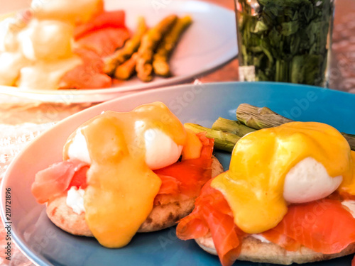 Poached eggs under hollandaise sauce on top of salmon fillet pieces and served on a pita bread. Healthy and freshly made at home breakfast concept.