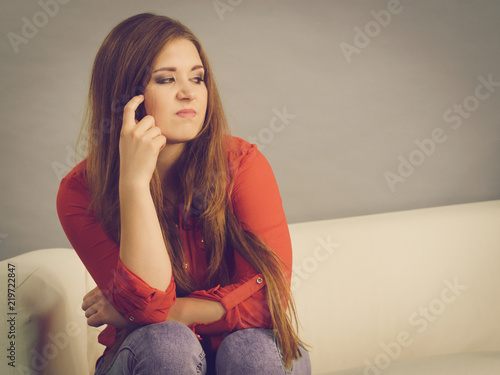 Angry woman sitting on sofa photo