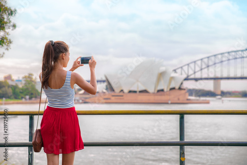 Sydney travel tourist woman taking phone picture of Opera house on Australia vacation. Asian girl using cellphone for photos during holiday.
