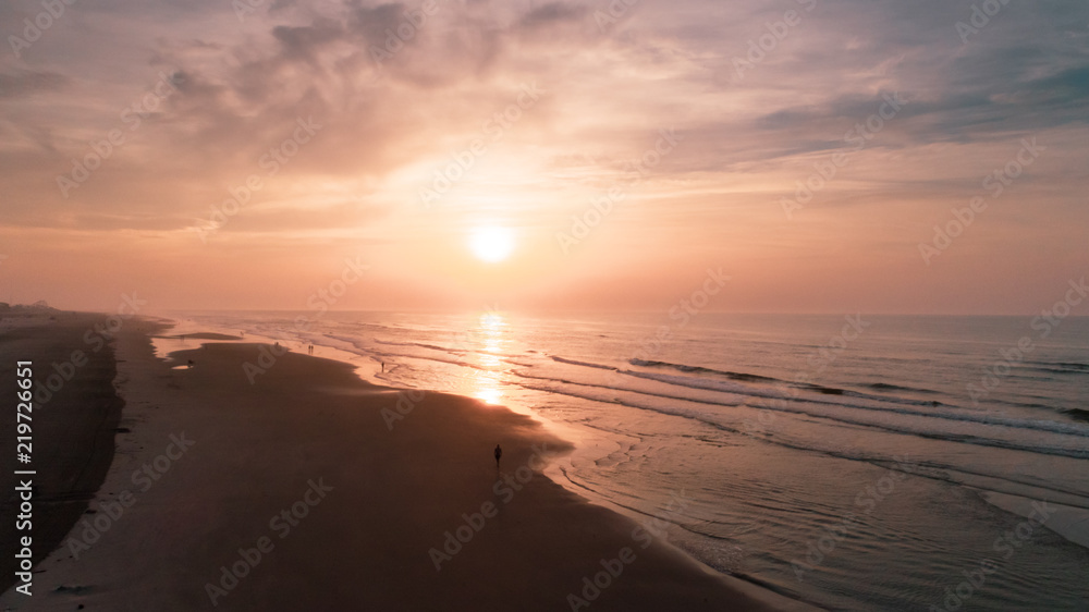 Beach Sunrise over Ocean and waves with cloudy purple yellow orange sky Aerial at New Jersey Shore