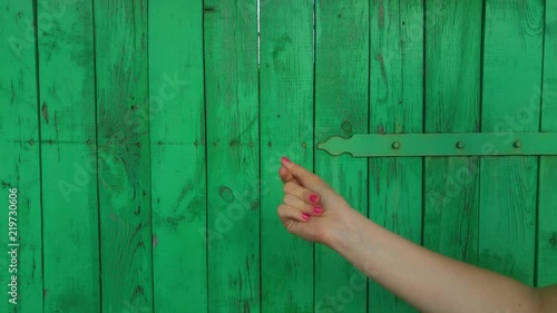 Female hand clicks fingers on a green wooden background