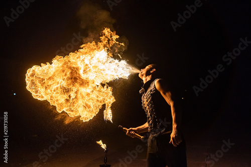 Fire show artist breathe fire in the dark photo