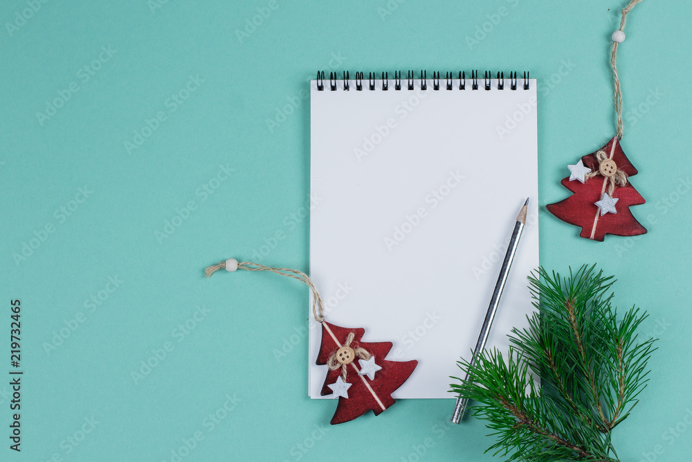 Fototapeta premium Christmas mock up blank greeting card. Fir tree branches and holday decorations over green paper background. Flat lay. Top view. Copy space