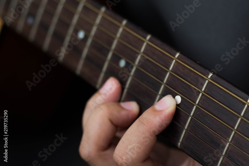 man hand on acoustic guitar chord