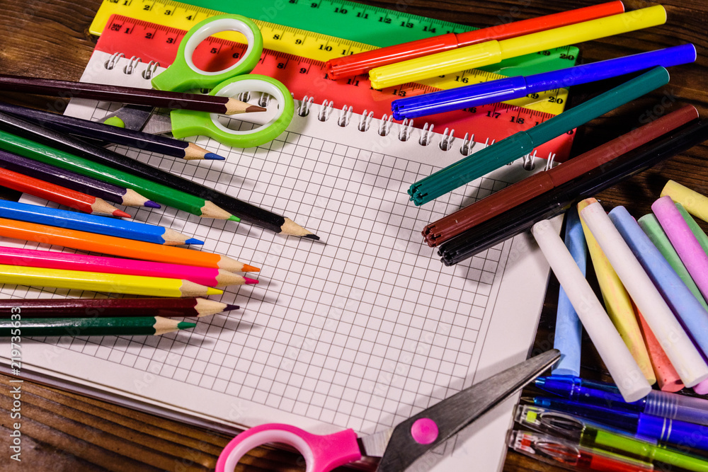 Different school stationeries on a dark wooden table Different school stationeries on a dark wooden table