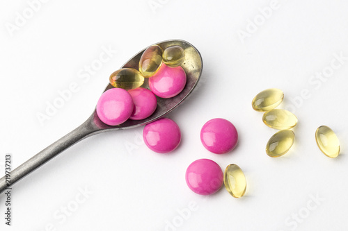 Assorted pharmaceutical medicine pills, tablets and capsules on steel spoon