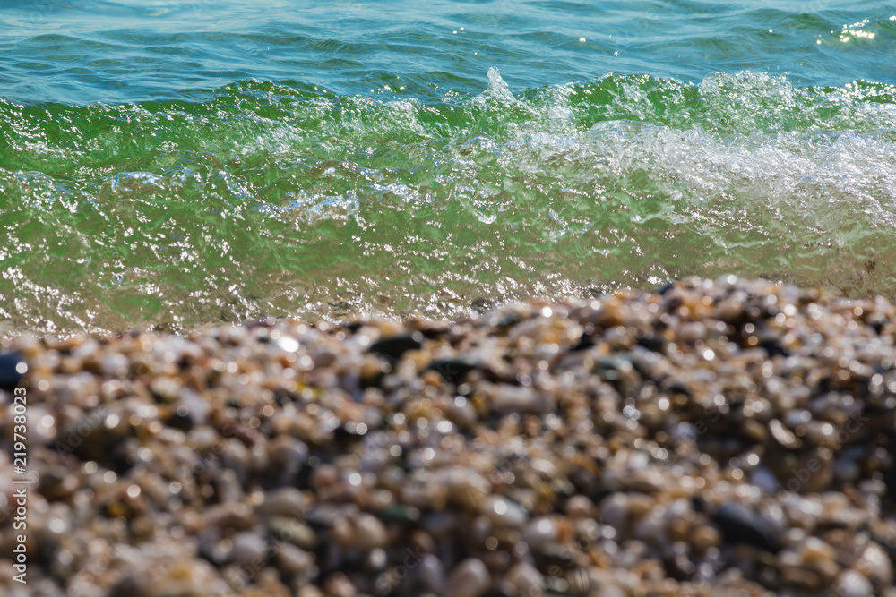Waves of the blue sea crashing onto a pebble beach in Maronia, Rodopi, Greece Waves of the blue sea crashing onto a pebble beach in Maronia, Rodopi, Greece