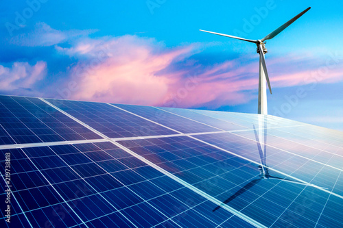 Wind turbines and solar panels closeup on sky background