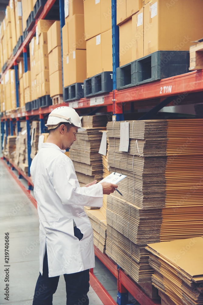 Young man white uniform checking stock at store factory Young man white uniform checking stock at store factory