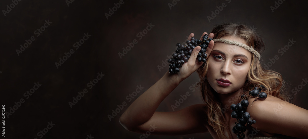 Portrait of blonde with blue grapes.