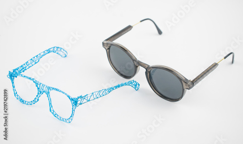Glasses made with a 3d pen and sunglasses on a white background.