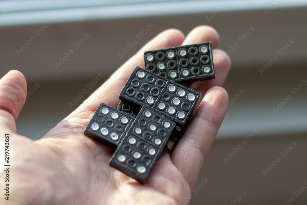 Black dominos lying in a human hand Black dominos lying in a human hand