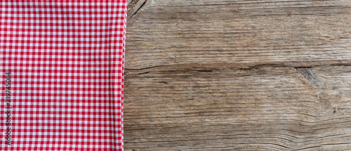 Red white checkered tablecloth on wooden table, banner, copy space