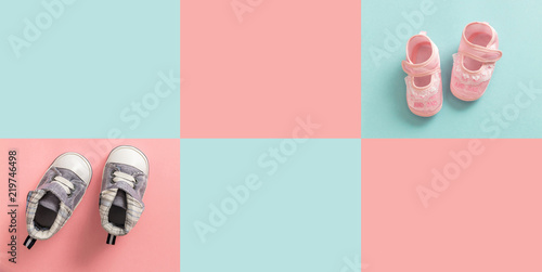 Baby boy and girl shoes on pastel colored background