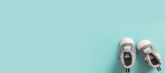 Baby boy shoes on pastel blue background, banner